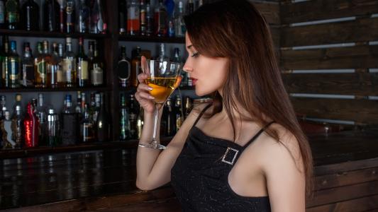一个女人在酒吧喝酒图片