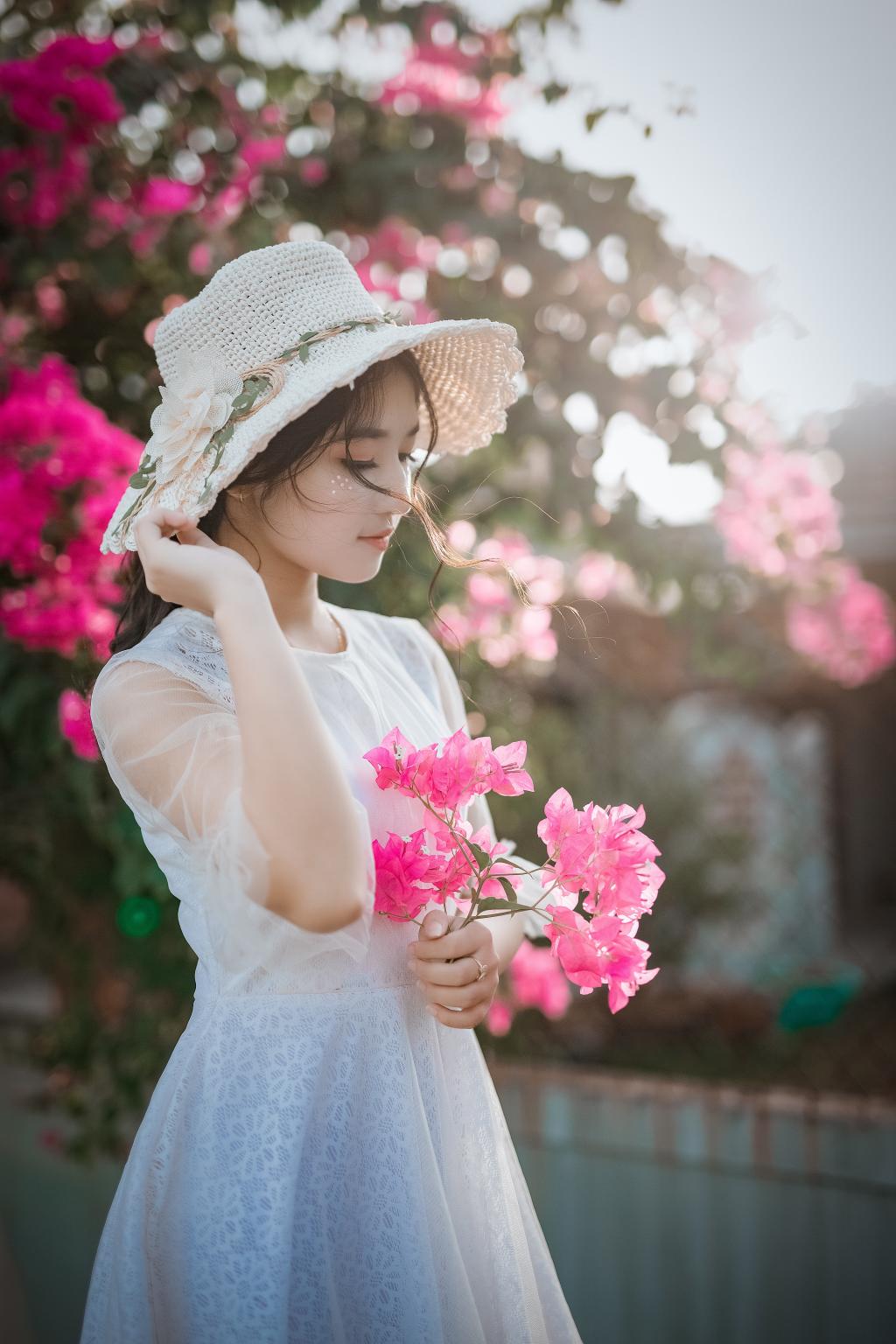 小女孩拿着一束鲜花站在公园的背景上照片摄影图片_ID:159982581-Veer图库