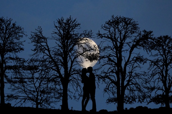 月下拥吻的情侣剪影图片