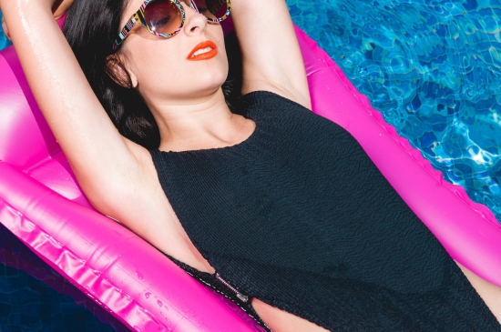 充气艇上享受夏日的泳池美女图片