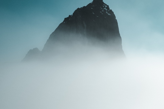 攀登者与云雾缭绕雾的高山图片